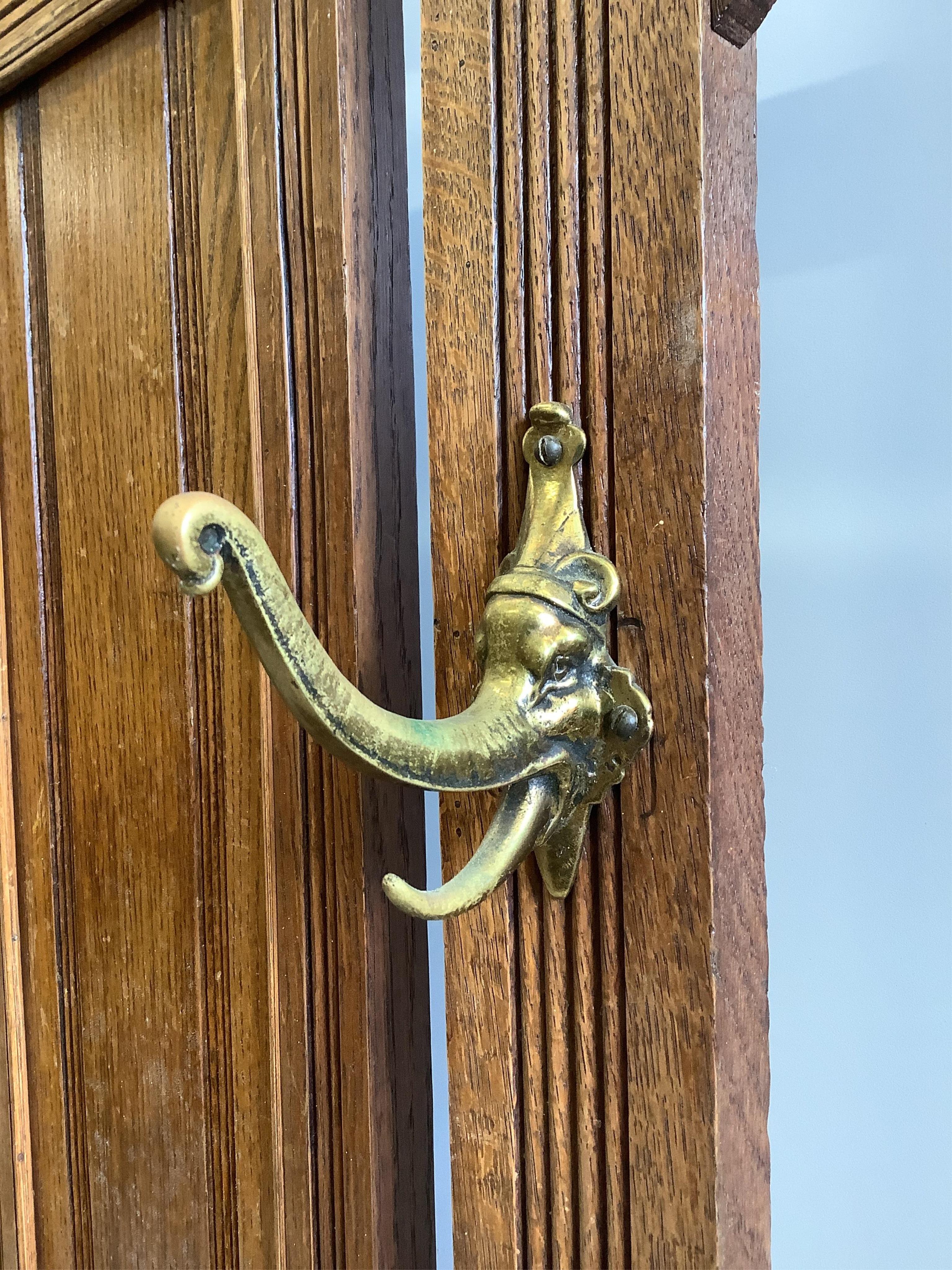 A late Victorian oak hallstand with cast brass elephant head hooks, width 115cm, height 210cm. Condition - fair